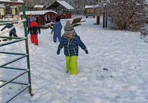 Dzieci bawią się w ogrodzie przedszkolnym na śniegu